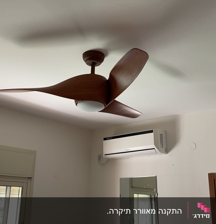 מאוורר תקרה מעץ ומזגן מותקן על הקיר